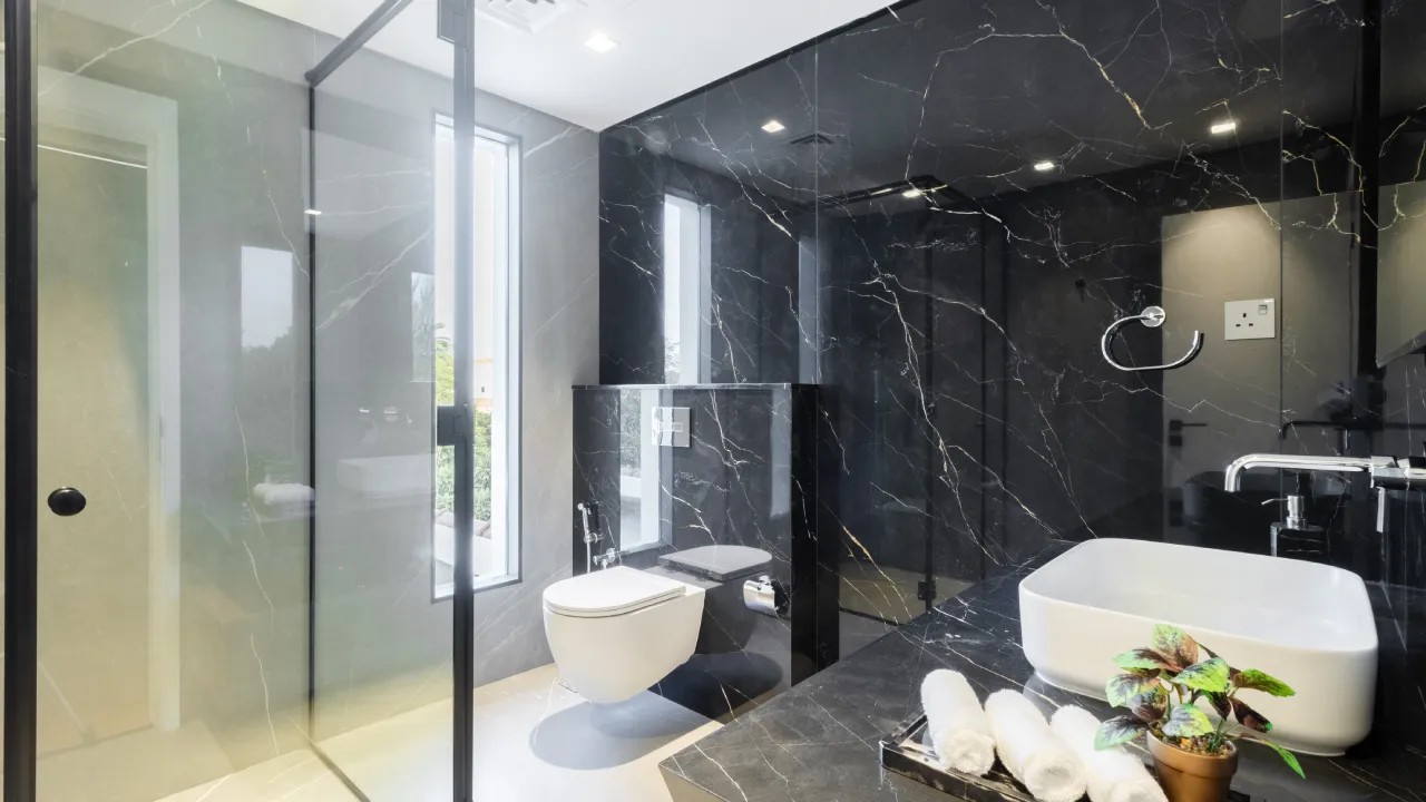 Black stone bathroom and glass shower in a house in Dubai