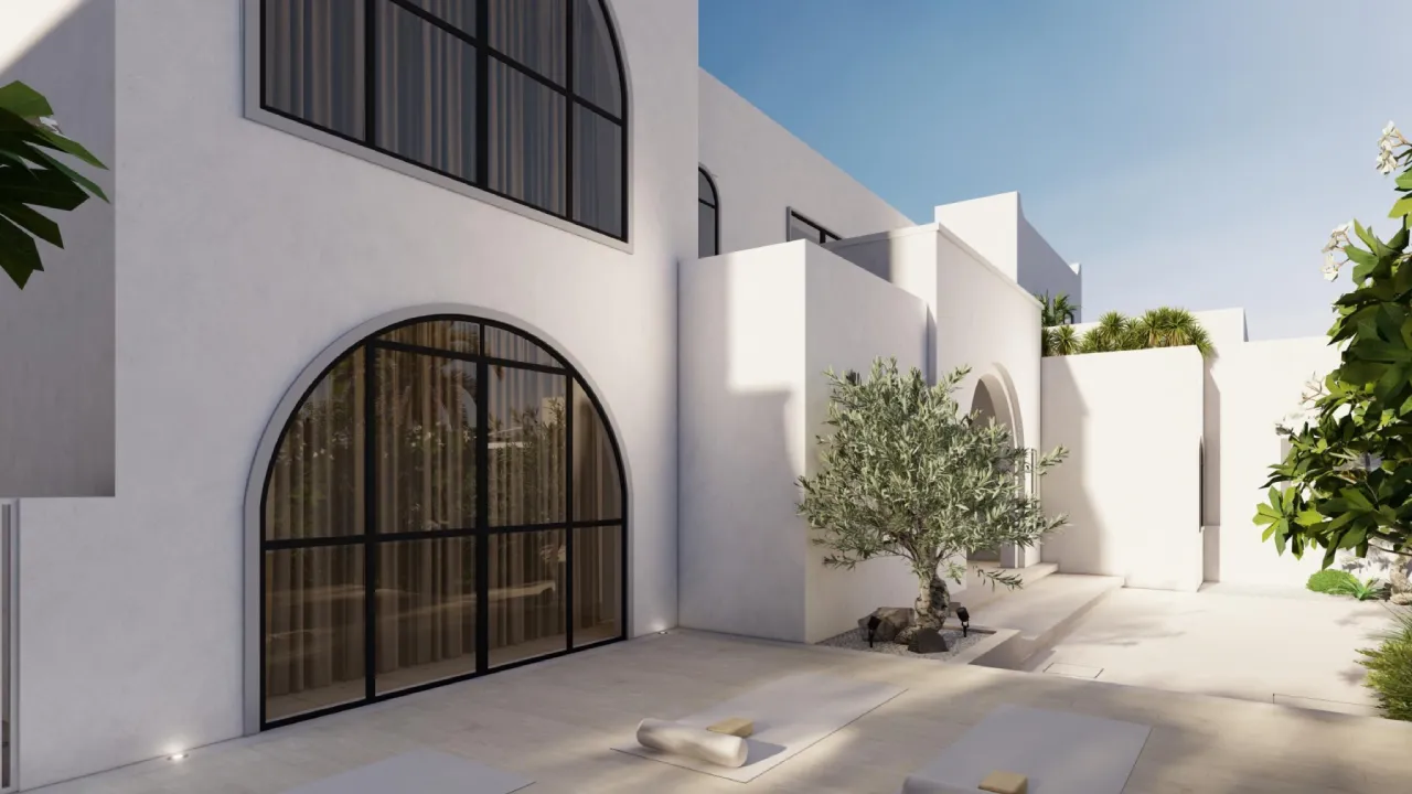White house exterior design with arched black-framed windows, soft paving, olive tree landscaping and private garden walls