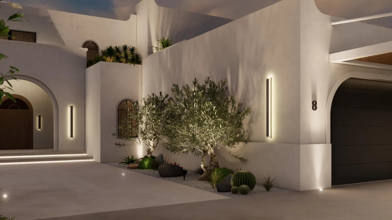 Night view of a white villa exterior in Jumeirah Islands with warm wall lights, arched entry and sculptural olive tree