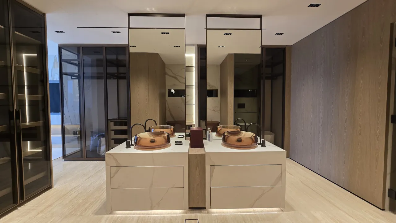 Luxury bathroom and dressing renovation with smoked glass wardrobes, double vanity, amber vessel basins, black taps and warm wood panels