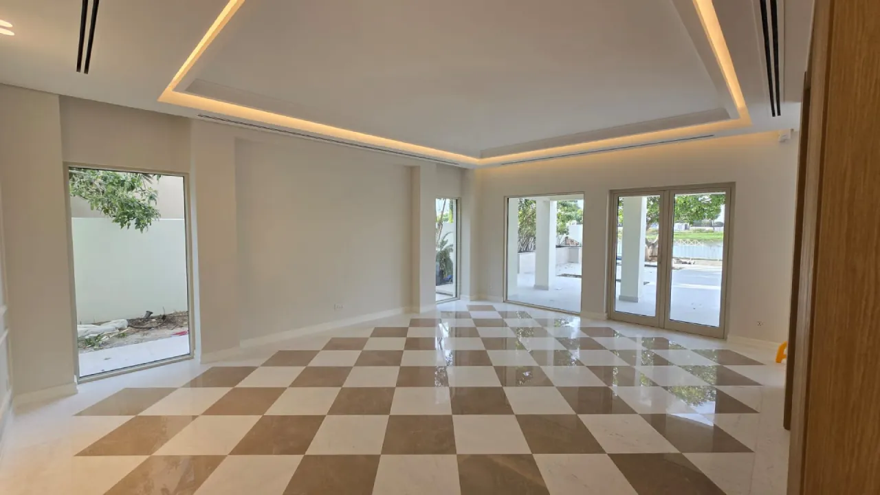 House renovation in Meadows Dubai with checkered floor, large garden-facing windows, recessed ceiling lighting, and open formal room layout.