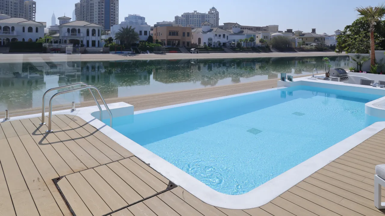 Modern Infinity Pool with Integrated Jacuzzi and Beach Access High-end Infinity pool with integrated Jacuzzi, terrace, outdoor kitchen, and beach access for a Dubai Palm villa project
