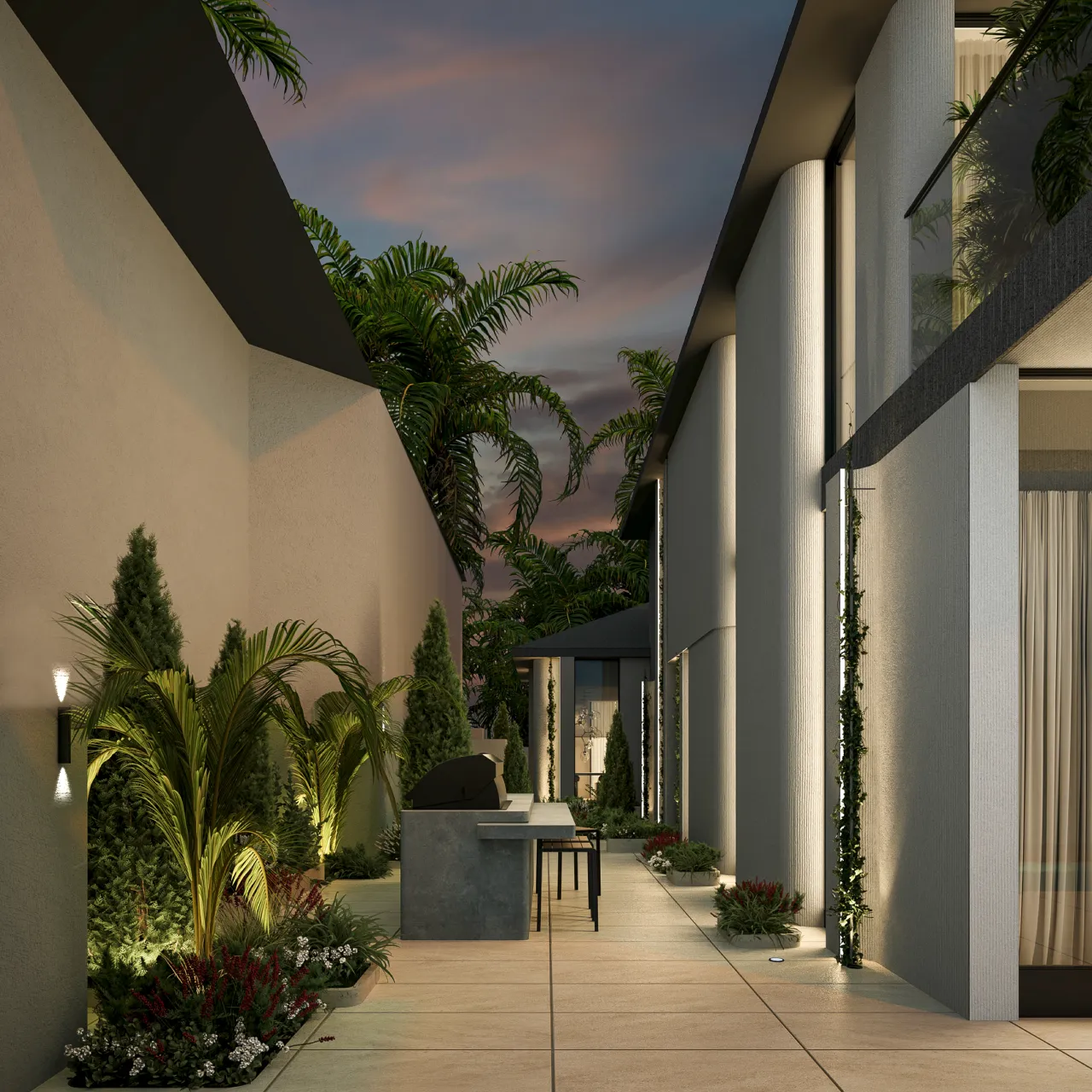 Night view of a modern luxury villa side exterior with sculptural white columns, full-height glass windows, warm facade lighting, pale walkway tiles, tropical planting, and clean boundary wall lighting.