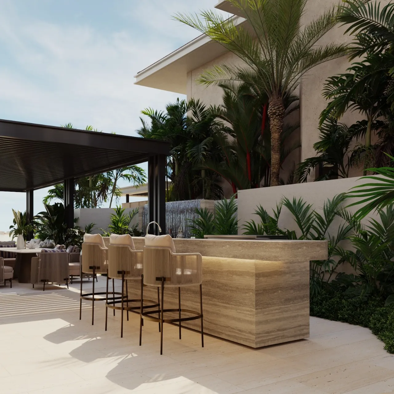 Modern outdoor bar with a travertine counter, woven bar stools, tropical palms, dense greenery, a water feature, and a shaded seating area.