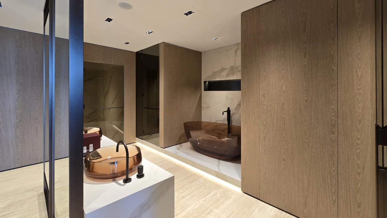 Amber freestanding bath framed by timber cabinetry in the remodeled master bathroom