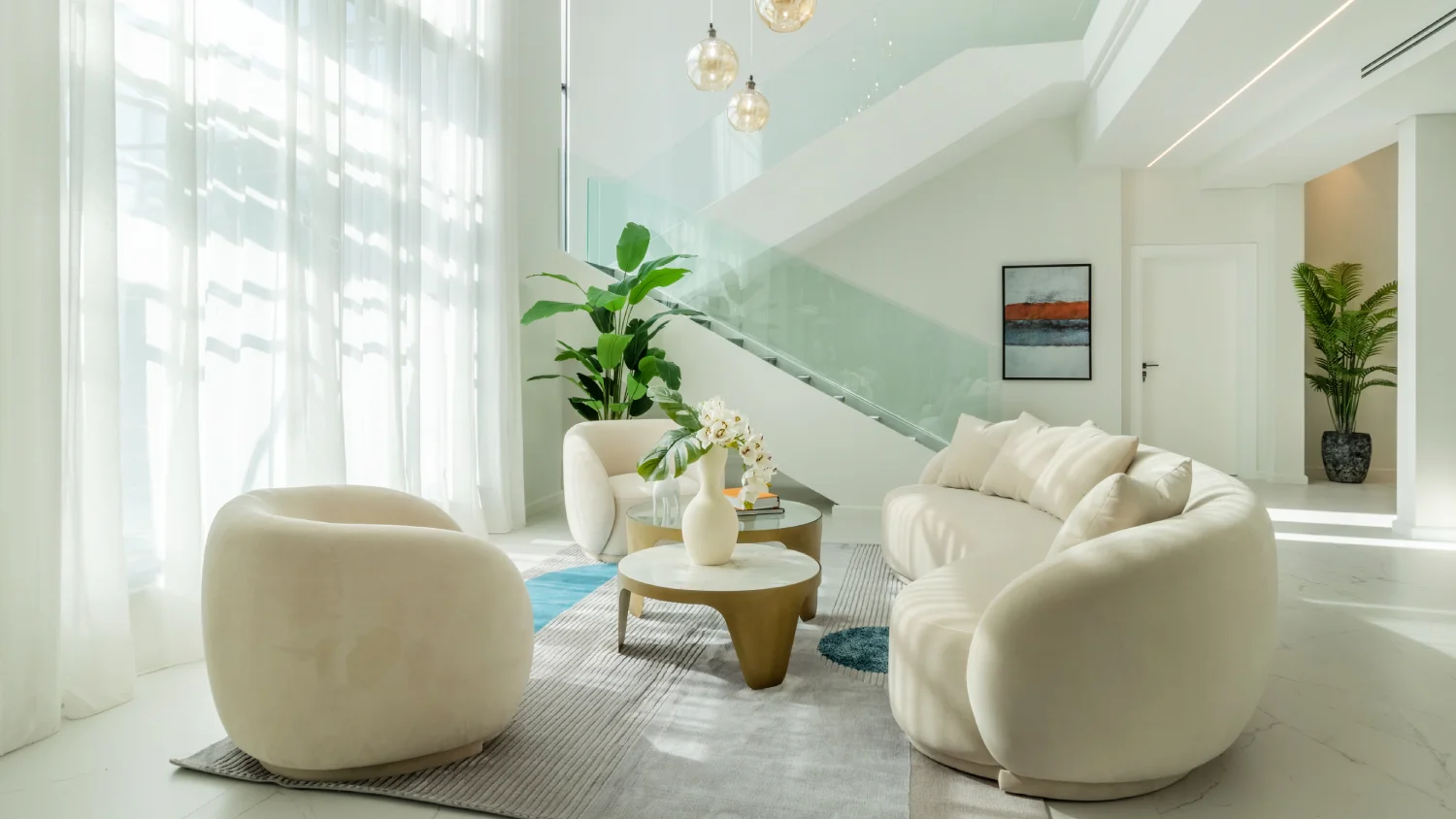 Double-height Jumeirah Islands lounge with curved cream seating, glass staircase, amber globe pendants, white orchids, indoor plants, and sheer curtains