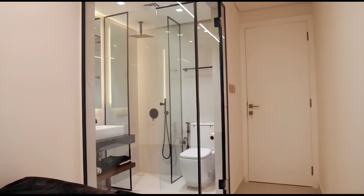 Black-framed glass shower enclosure, floating vanity and modern bathroom fittings in a renovated Dubai apartment