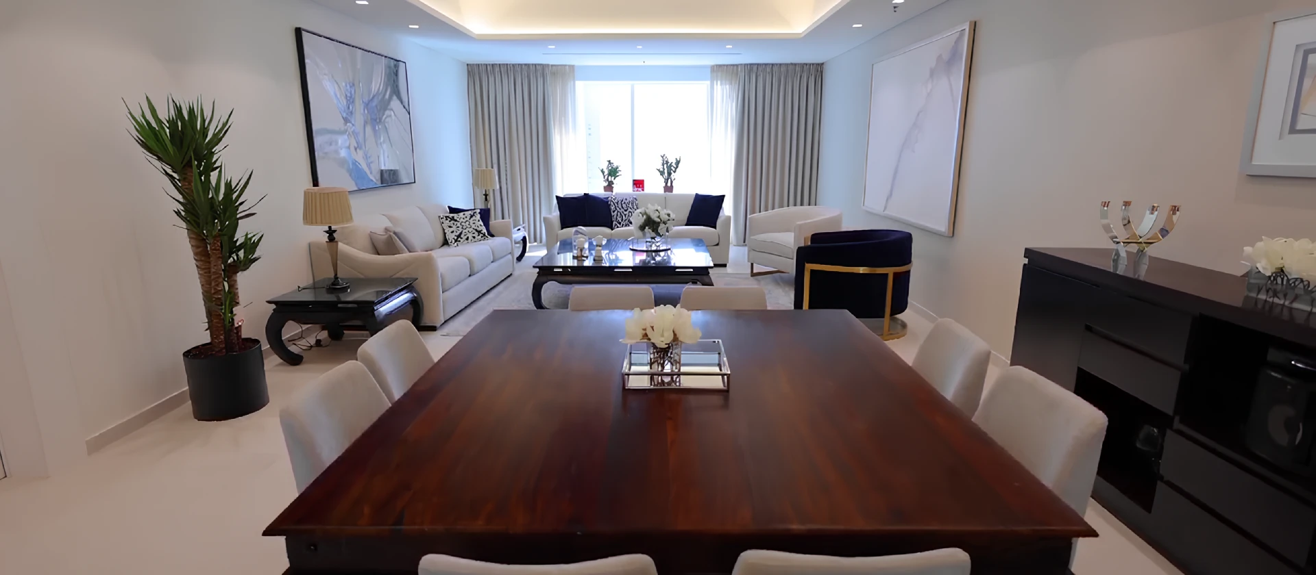 Open living and dining room after Arta's Emirates Crown apartment renovation in Dubai Marina, with cove lighting and pale flooring