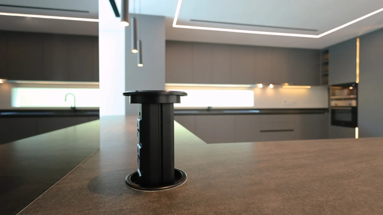 Retractable black power socket installed in the kitchen island of a renovated Jumeirah Park home