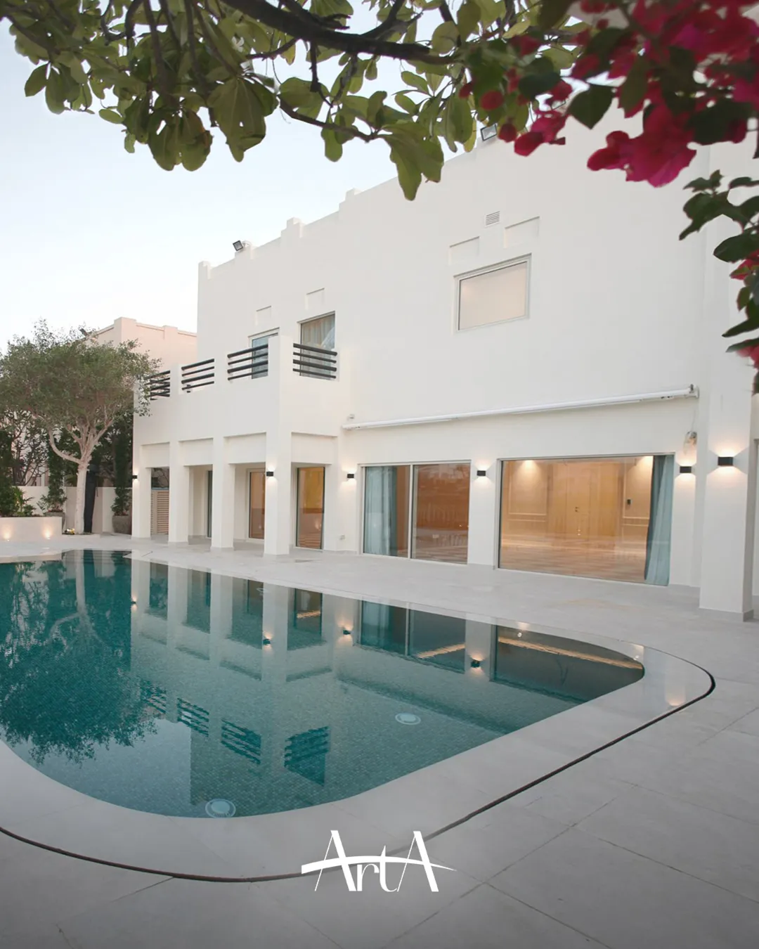 Completed Meadows villa poolside elevation with white facade, black balcony rails, finished terrace and green mosaic swimming pool.