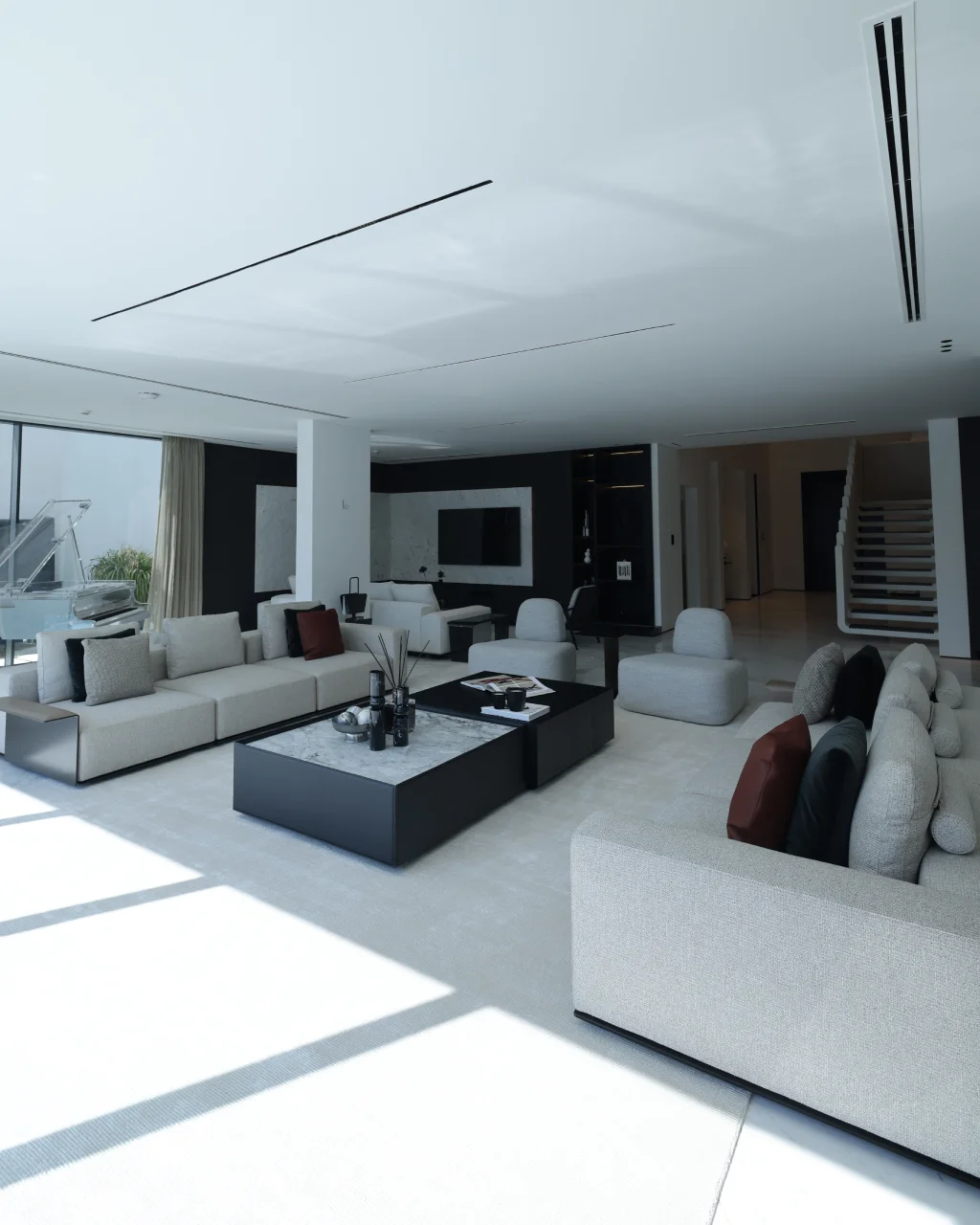 Monochrome Palm Jumeirah living room with cream sofas, black coffee tables, marble TV wall, open staircase view, transparent piano, and waterfront glazing