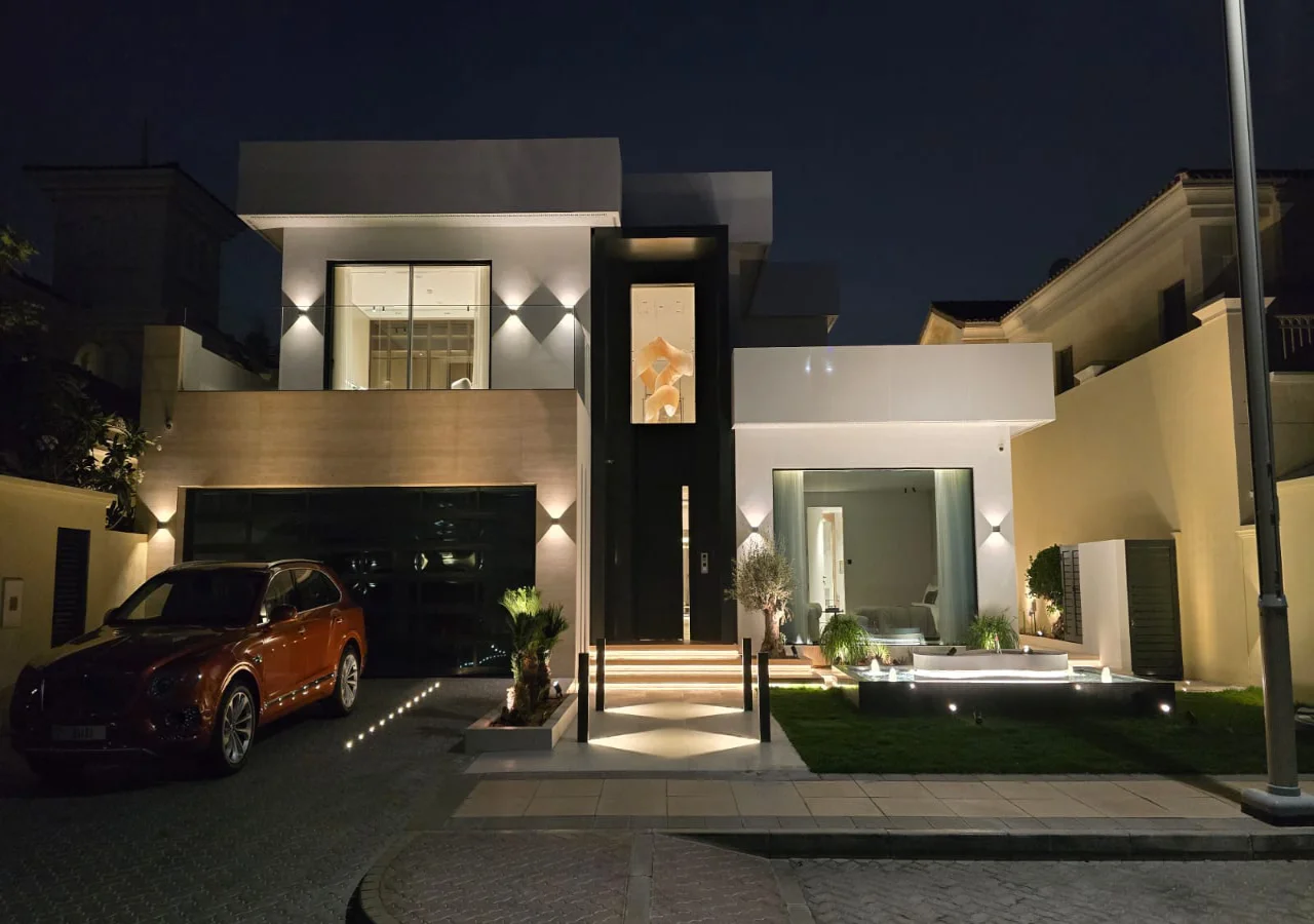 Contemporary Palm Jumeirah villa facade after renovation with flat rooflines, dark garage, tall entrance and integrated lighting