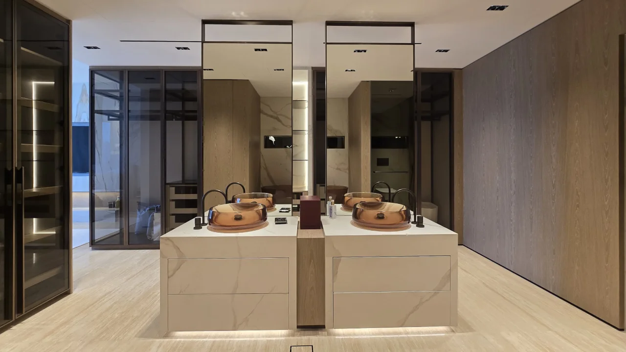 Master bathroom after renovation with two central vanity islands and full-height mirrors