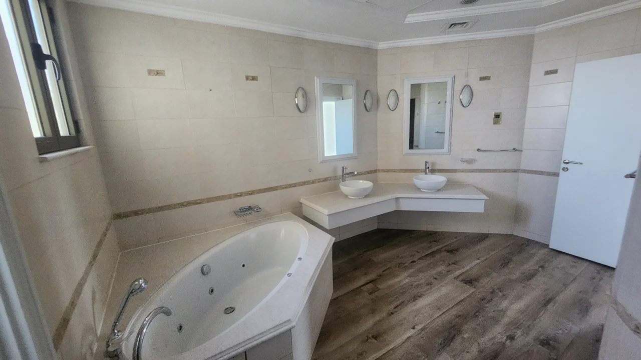 Master bathroom before remodeling with corner bath and angular double vanity