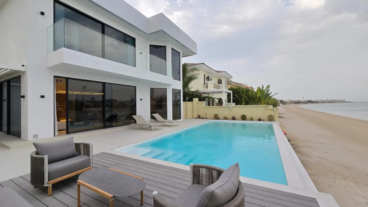 Palm Jumeirah swimming pool after remodeling with enlarged rectangular water area, broad entry steps, pale terrace and open beach view
