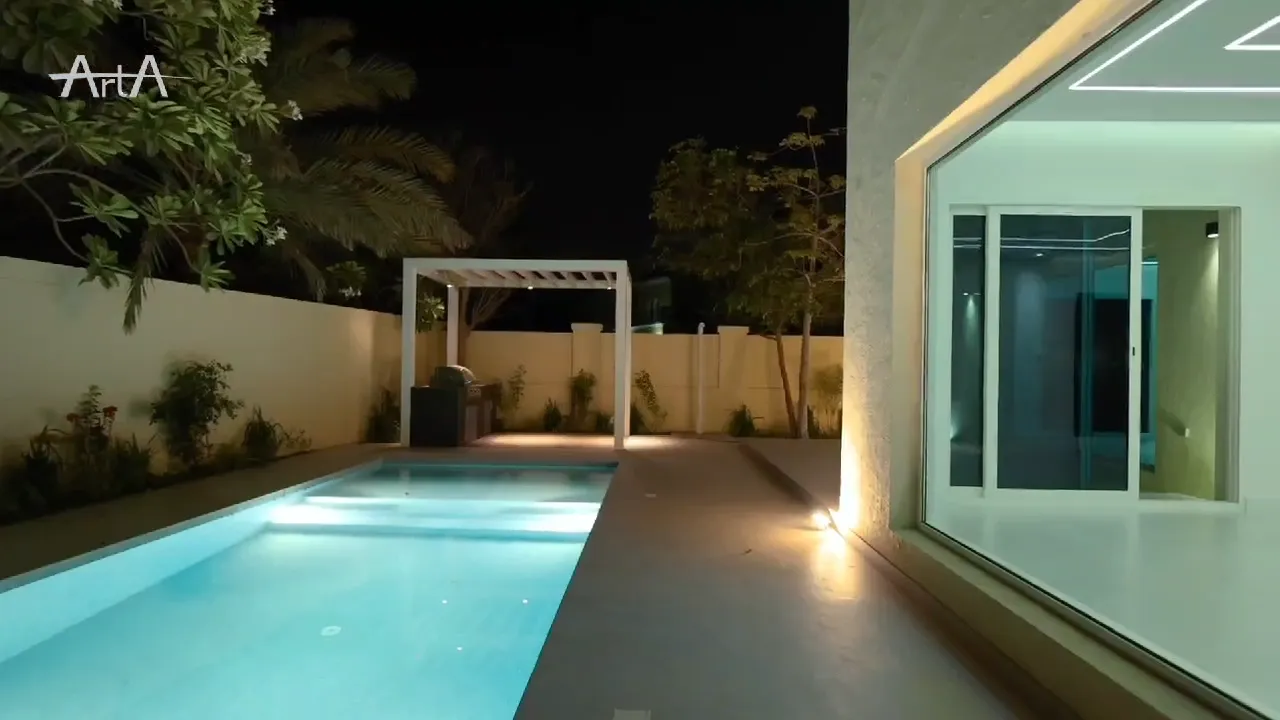 Illuminated Jumeirah Park swimming pool and terrace at night after construction