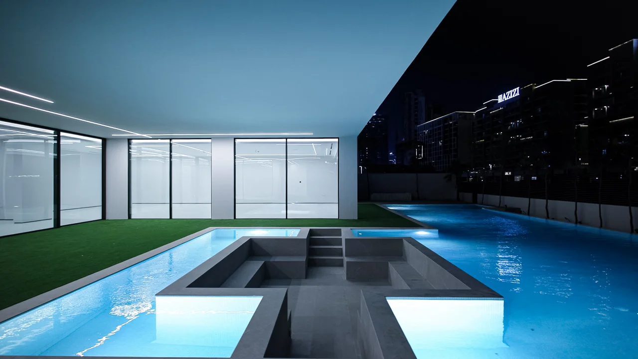 Close view of the built-in sunken pool seating with central access steps and illuminated water channels