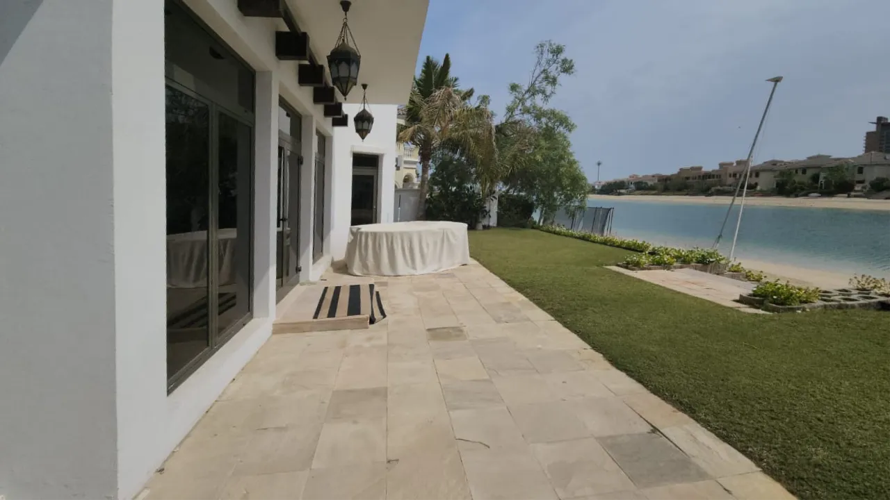 Waterfront lawn and stone terrace before new swimming pool construction at Palm Jumeirah villa