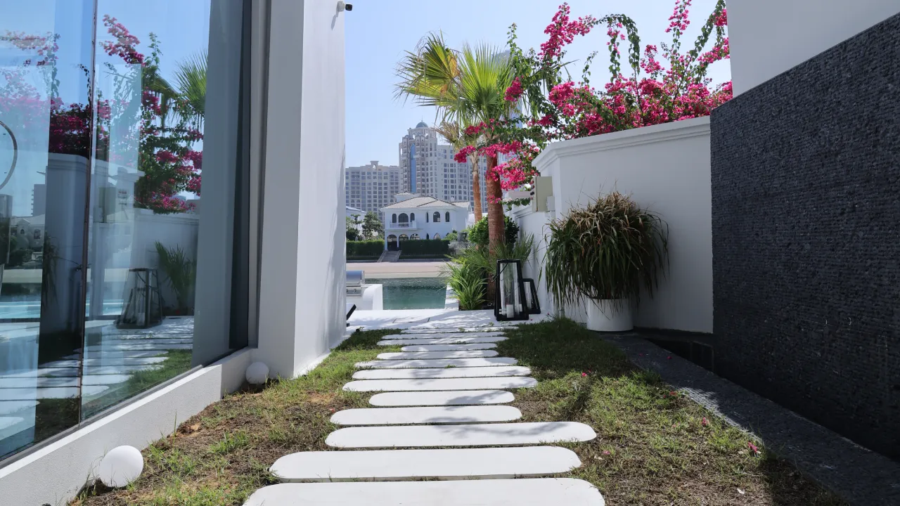 Landscaped side garden with white stepping stones planting and dark feature wall after removal of original swimming pool