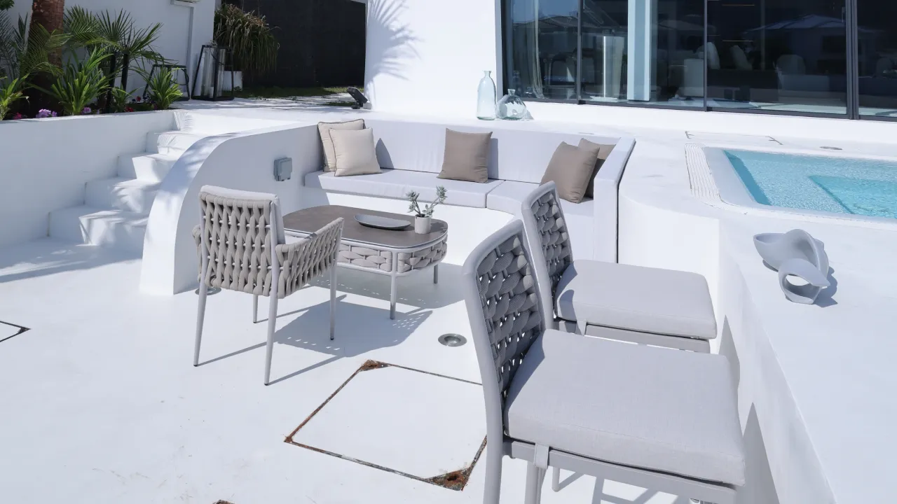 Poolside outdoor kitchen BBQ sink bar stools and built-in lounge at renovated Palm Jumeirah villa