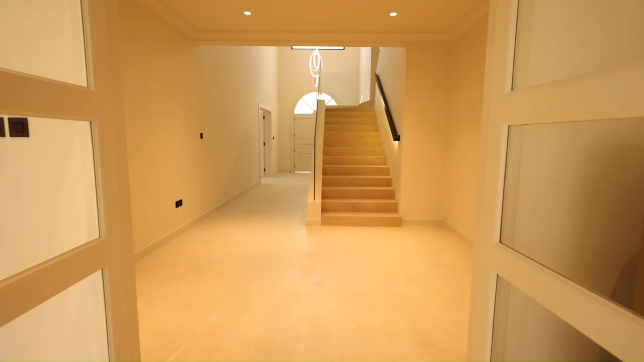 Sand House Garden Home renovation on Palm Jumeirah with sand-toned microcement, illuminated staircase and glass balustrade