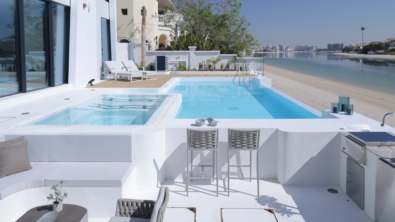 Completed waterfront swimming pool with integrated spa deck and lounge area at renovated Palm Jumeirah Garden Home