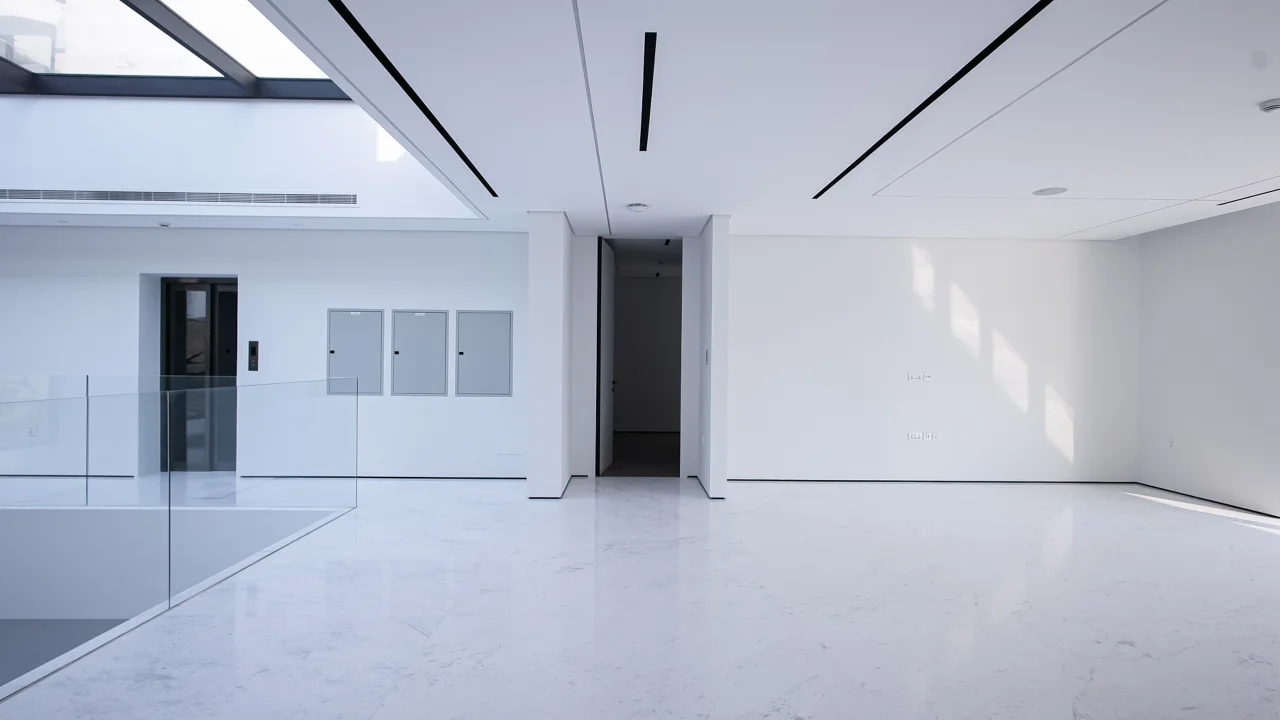 First-floor hall with white stone flooring, glass gallery balustrade, linear air-conditioning slots and recessed lighting