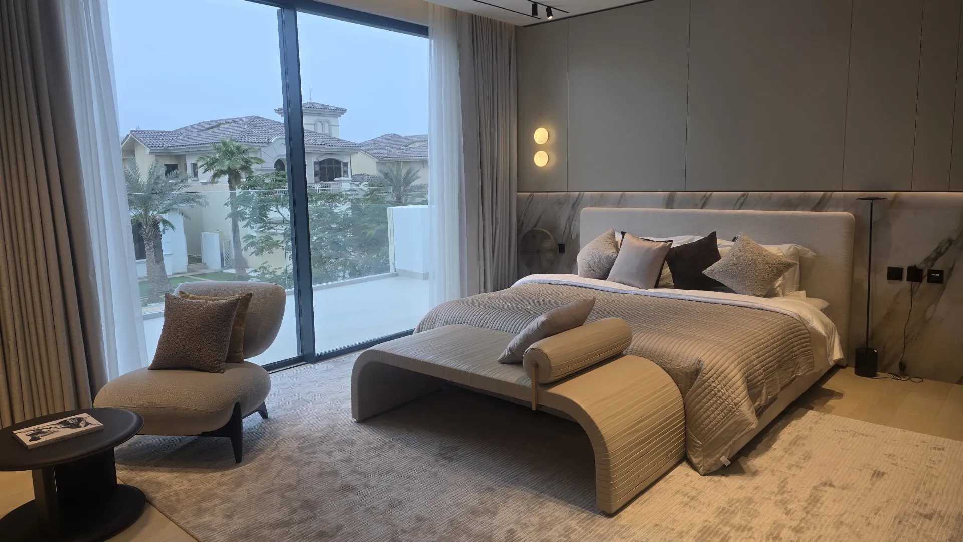 Completed modern taupe bedroom after full renovation showing the integrated bed with a luxury headboard, storage and dressing areas