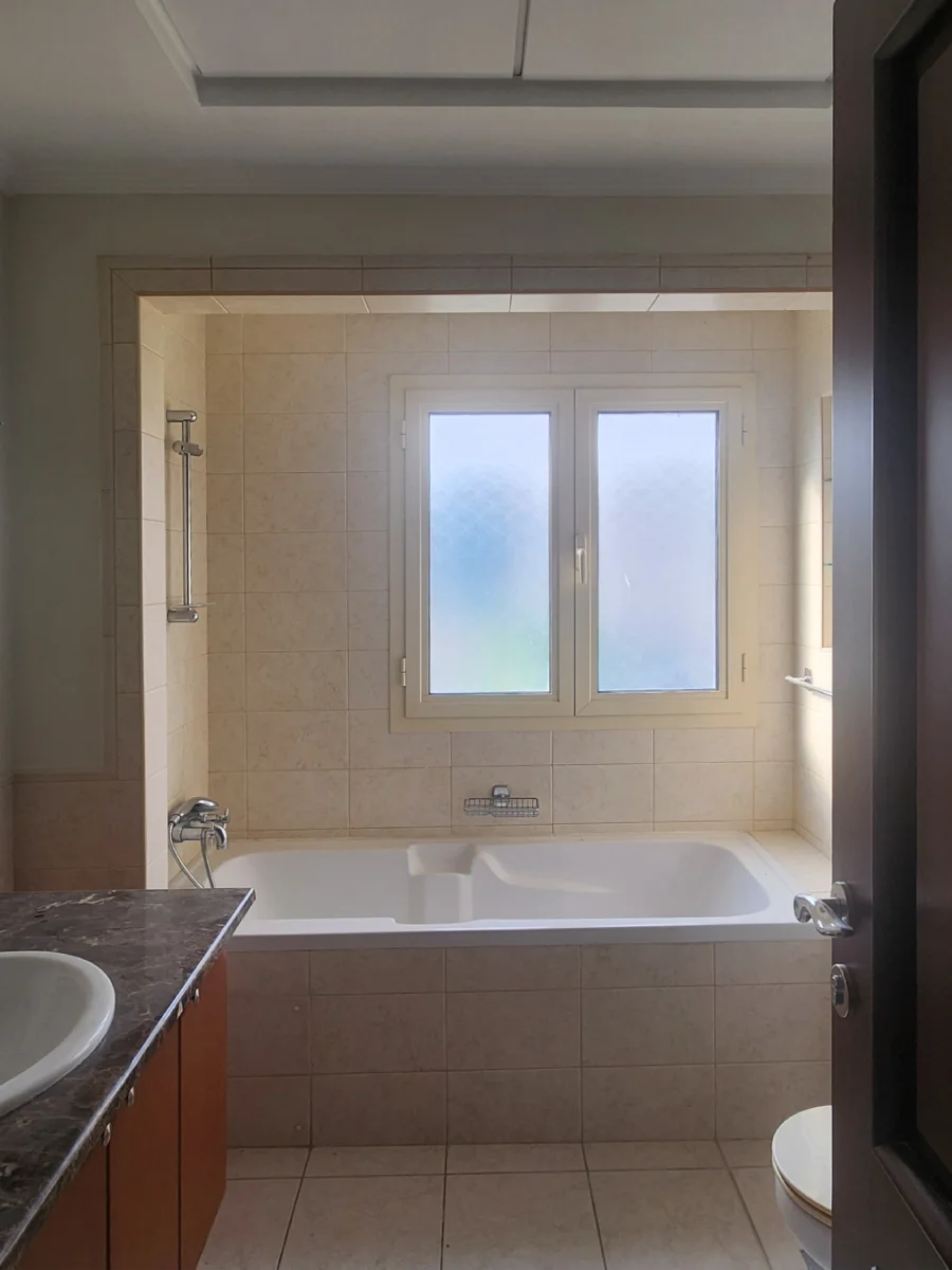 Meadows bathroom before renovation with built-in bathtub, beige tiles and framed bath opening