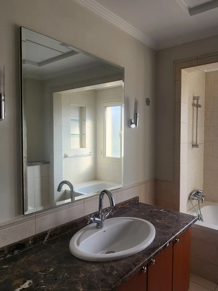 Meadows bathroom before renovation with dark marble vanity, inset basin and timber cabinet