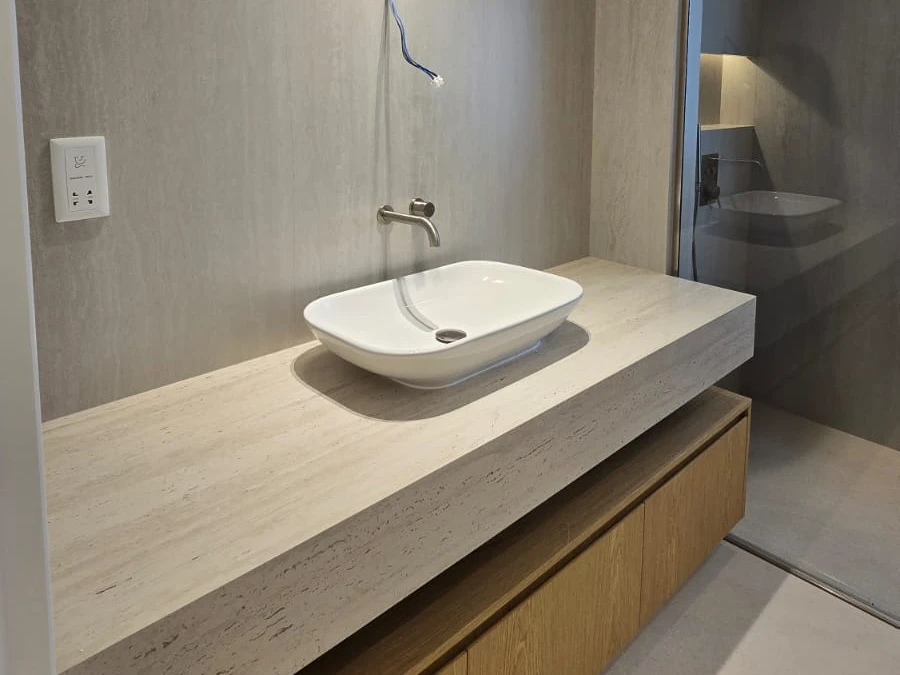Renovated floating oak bathroom vanity with pale stone counter, vessel basin and wall mounted tap