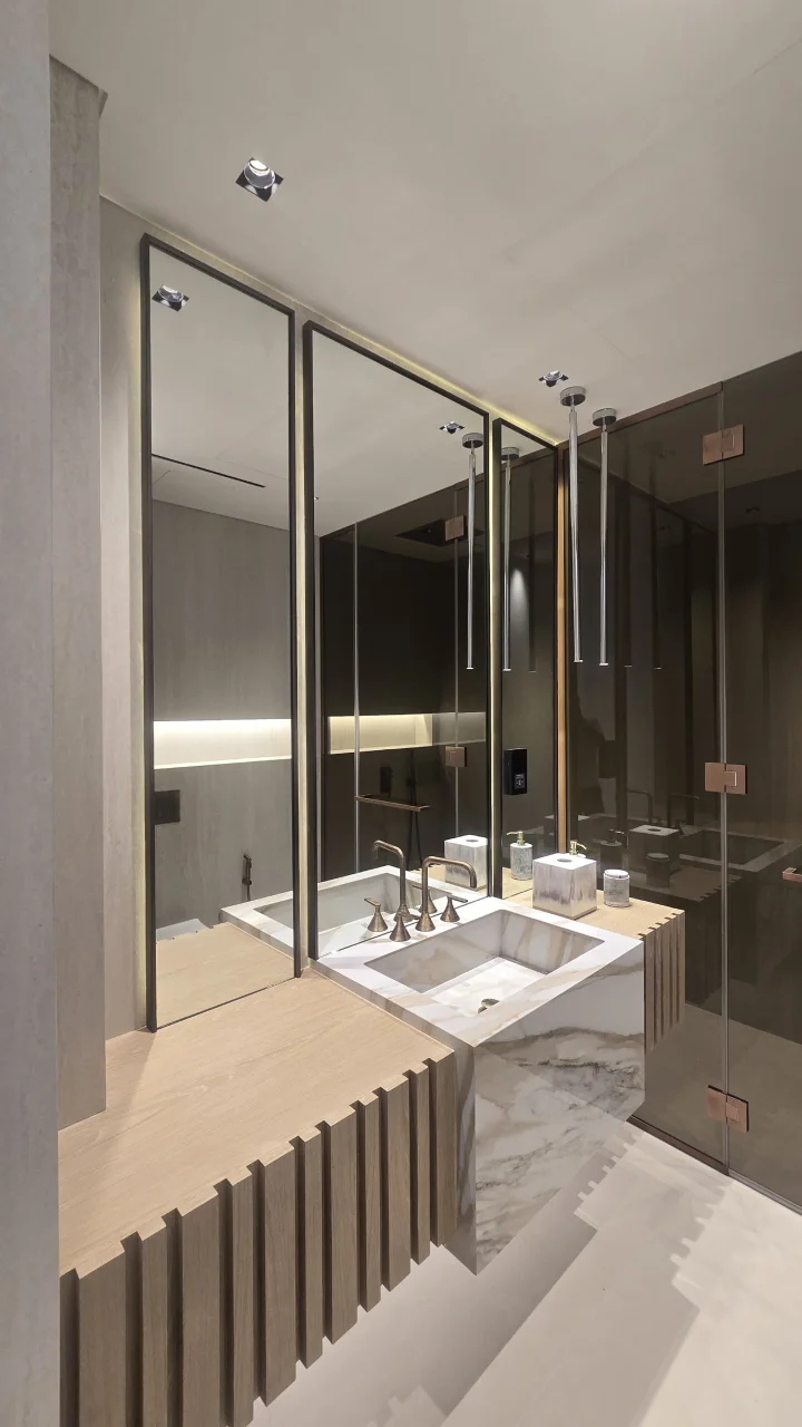 Palm Jumeirah bathroom after renovation with oak vanity, stone basin, tall mirrors and bronze glass