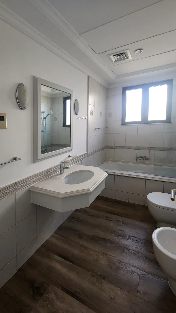 Original bathroom vanity with projecting basin, small framed mirror and decorative tile border