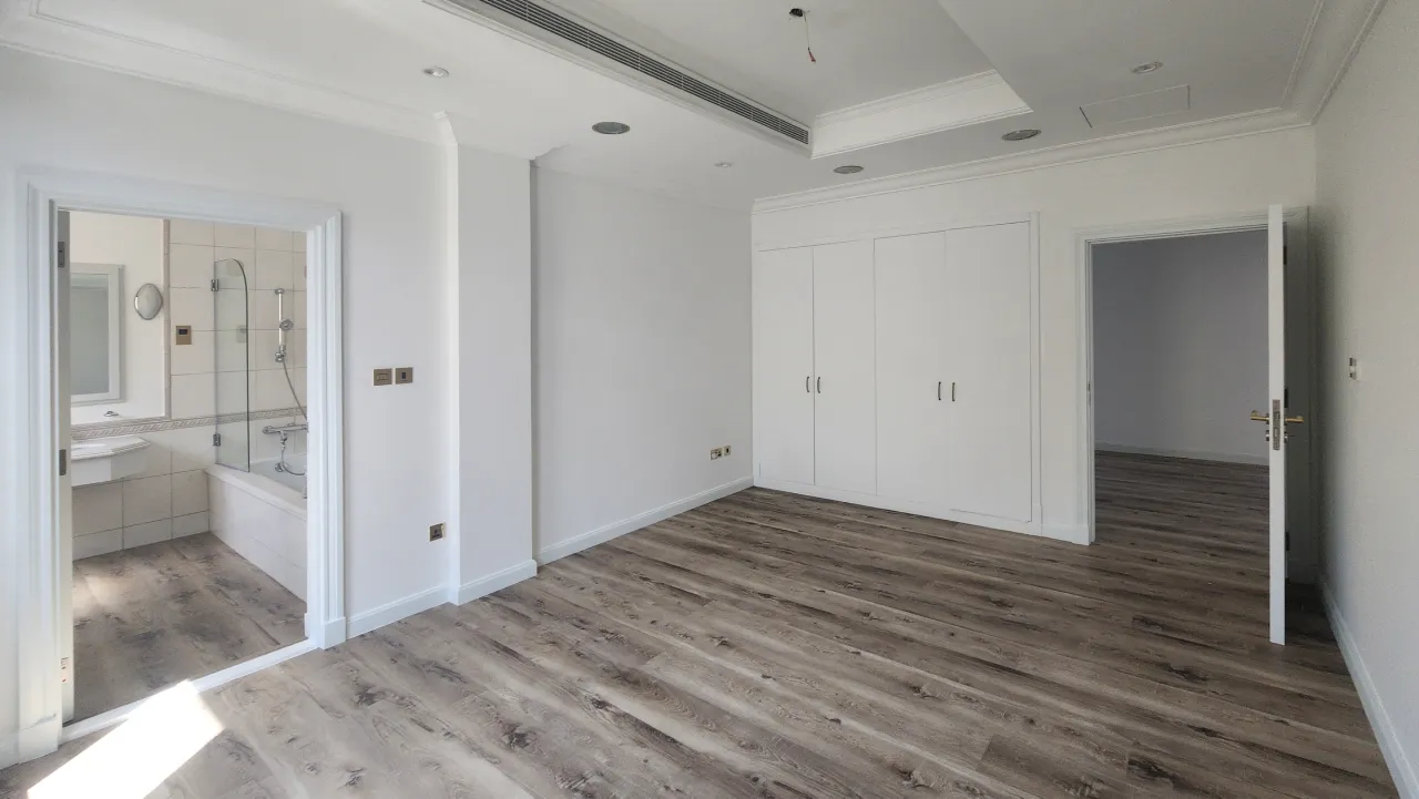 Guest bedroom before renovation in Palm Jumeirah villa with built-in wardrobe and attached bathroom entrance
