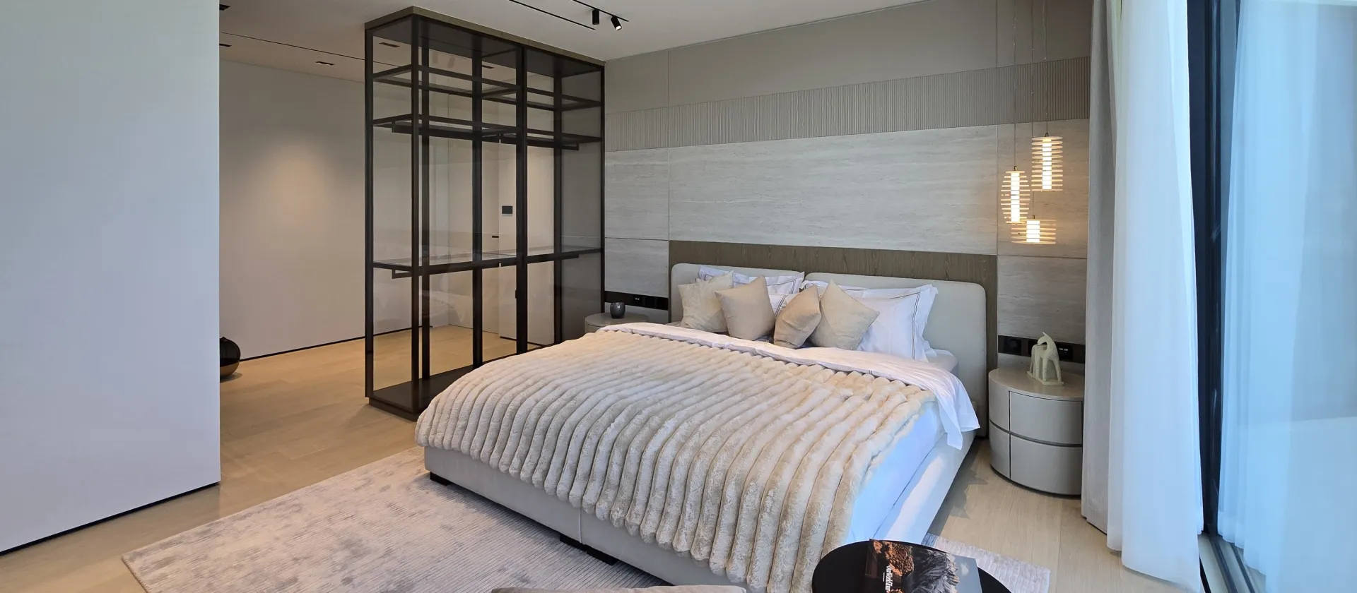 Palm Jumeirah bedroom after renovation with stone feature wall, glazed dressing area and waterfront setting